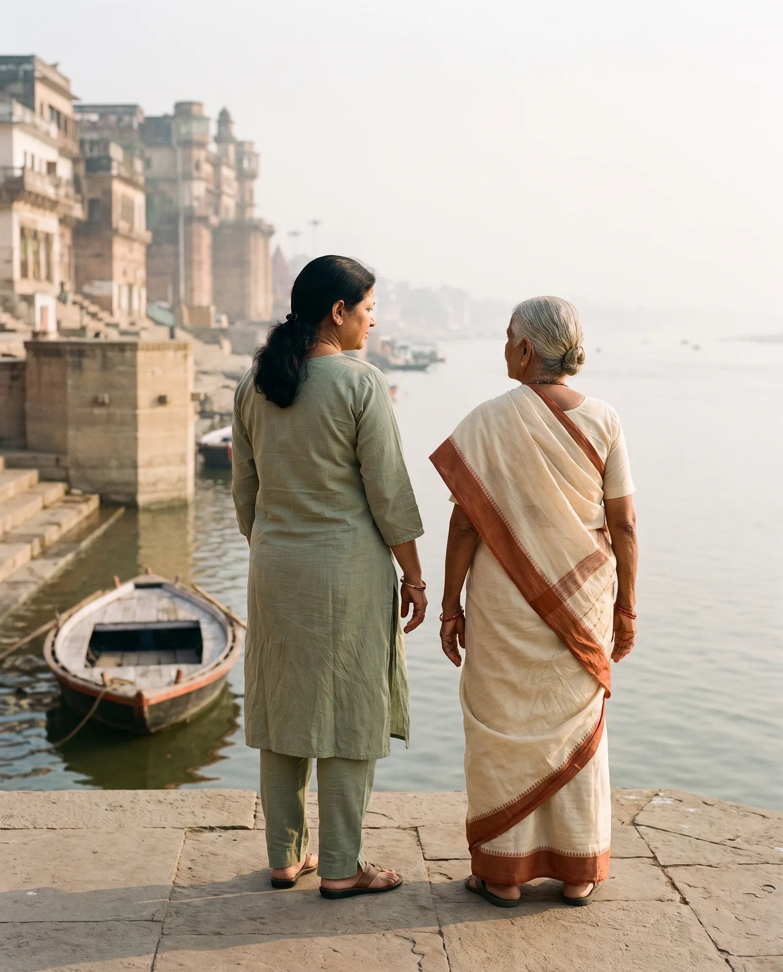 Illustrative scene of a mother and adult daughter beside the Ganga